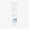 ROUND LAB 1025 Dokdo Eye Cream in einer weißen Tube mit minimalem Text und einer kleinen grünen Hügelillustration am unteren Rand.