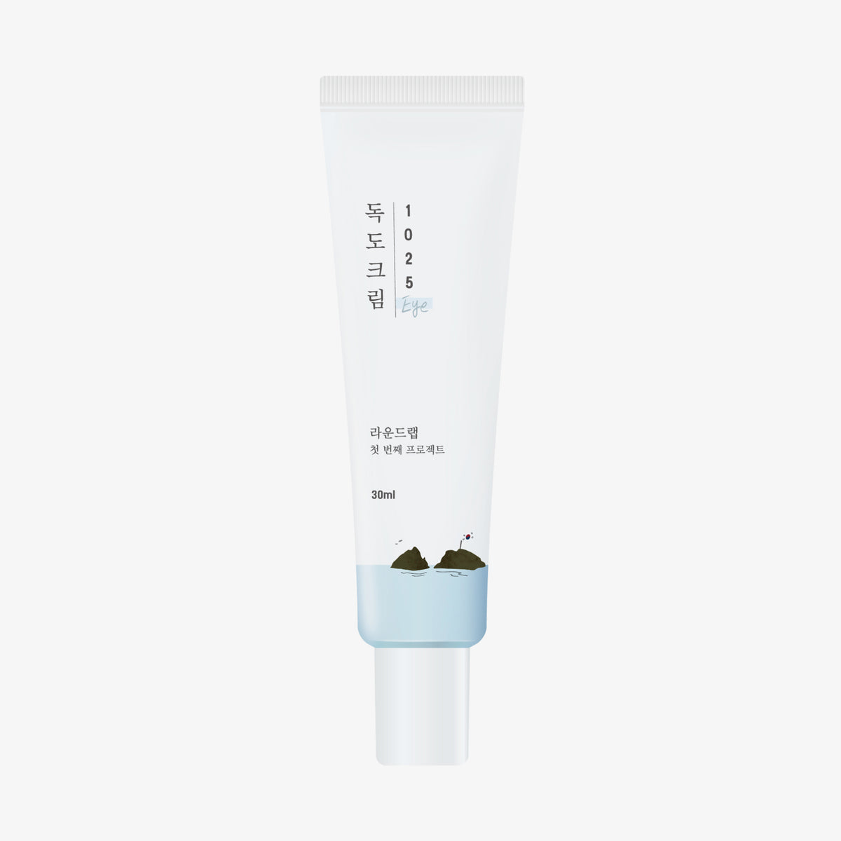 ROUND LAB 1025 Dokdo Eye Cream in einer weißen Tube mit minimalem Text und einer kleinen grünen Hügelillustration am unteren Rand.