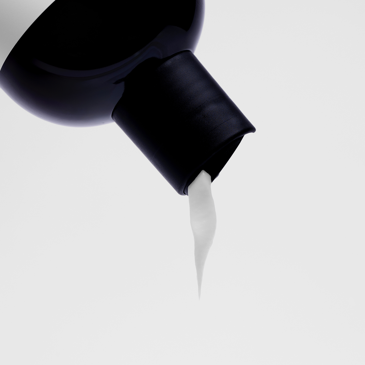 Eine Flasche Bio-Pilixin® Conditioner+ Men von Scandinavian Biolabs mit Klappverschluss spendet einen Strahl weißer Lotion vor einem schlichten Hintergrund.