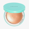 Eine türkisfarbene Puderdose mit der Aufschrift „SWEED“ enthält den Highlighter mit goldenem Schimmer; auf dem Deckel und am inneren Rand ist das Markenlogo zu sehen.