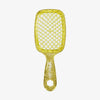 Gelbe UNbrush® Amber Entwirrbürste mit goldglitzerndem Waben-Design und ergonomischem Griff mit Markennamen.