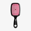 Die UNbrush Detangling Hair Brush hat ein schwarzes Paddle-Design mit rosa Borsten und einem sechseckigen Loch im Griff.