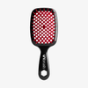 Die UNbrush Detangling Hair Brush ist schwarz mit roten Borsten und einem sechseckigen Loch im Griff.