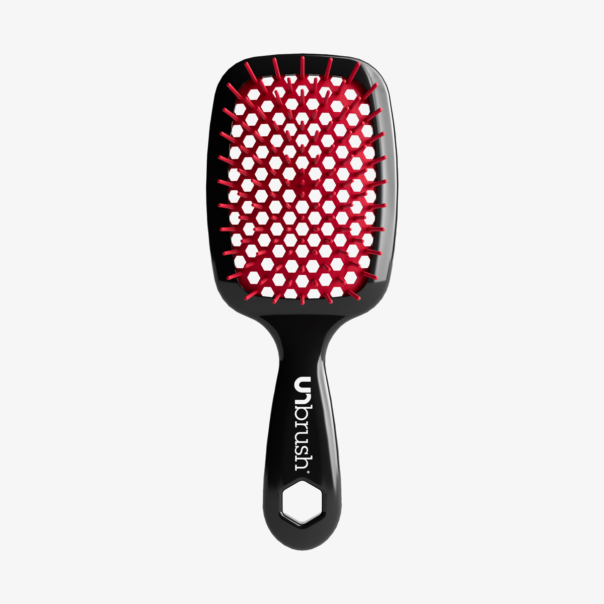 Die UNbrush Detangling Hair Brush ist schwarz mit roten Borsten und einem sechseckigen Loch im Griff.