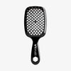 Die schwarze UNbrush Detangling Hair Brush hat einen wabenförmigen Bürstenkopf mit dem Schriftzug "UNbrush" auf dem Griff.