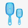 Das UNbrush Glitter Duo Set Sapphiere Blue besteht aus zwei blauen, glitzernden Haarbürsten in verschiedenen Größen mit belüfteten Paddel-Designs auf weißem Hintergrund.