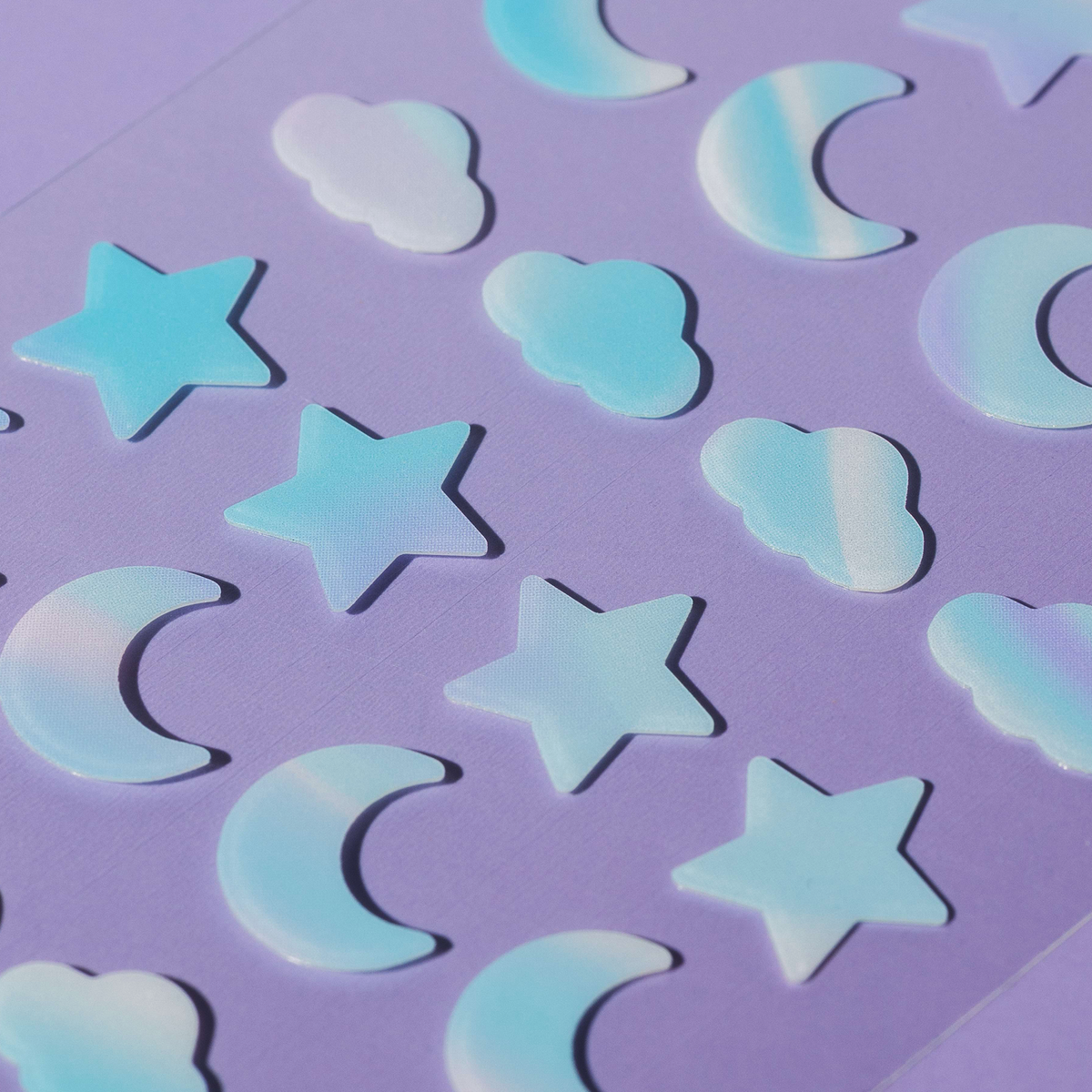 Ein Bogen mit blau-weißen Magic Dream Dots-Aufklebern in Form von Monden, Sternen und Wolken.