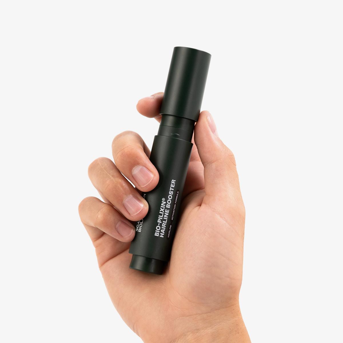 Eine Hand hält eine dunkelgrüne Scandinavian Biolabs Bio-Pilixin® Hairline Booster Flasche auf weißem Hintergrund.