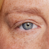 Nahaufnahme eines blauen Auges und einer Augenbraue, die mit dem Brow Booster von XLASH betont wurden.