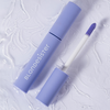 Eine lavendelfarbene Tube des „2 IN 1 EYES FIRST LASH&BROW SERUM“ von BLONDESISTER mit Applikator auf einer strukturierten weißen Oberfläche.