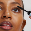 Eine Frau trägt mit einem Mascara-Bürstchen die XLASH Weightless Mascara auf ihre oberen Wimpern auf.