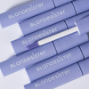 Sieben Tuben „BLONDESISTER 2 IN 1 EYES FIRST LASH&BROW SERUM“, von denen eine geöffnet ist, um den Applikator zu zeigen, ordentlich angeordnet.