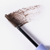 Die „BLONDESISTER 4 IN 1 CLICK & TURN MASCARA“-Bürste mit schwarzer Mascara, die auf Papier aufgetragen wurde, verdeutlicht die Textur und die Details der Bürste.