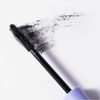 Die Bürste der BLONDESISTER 4-IN-1-CLICK-&-TURN-MASCARA hinterlässt mit ihren Borsten einen dunklen Streifen auf einer weißen Oberfläche.