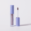 Eine Tube BLONDESISTER GLOWEYE EYESHADOW mit einer hellvioletten Kappe und dem dazugehörigen Applikator, der daneben liegt.