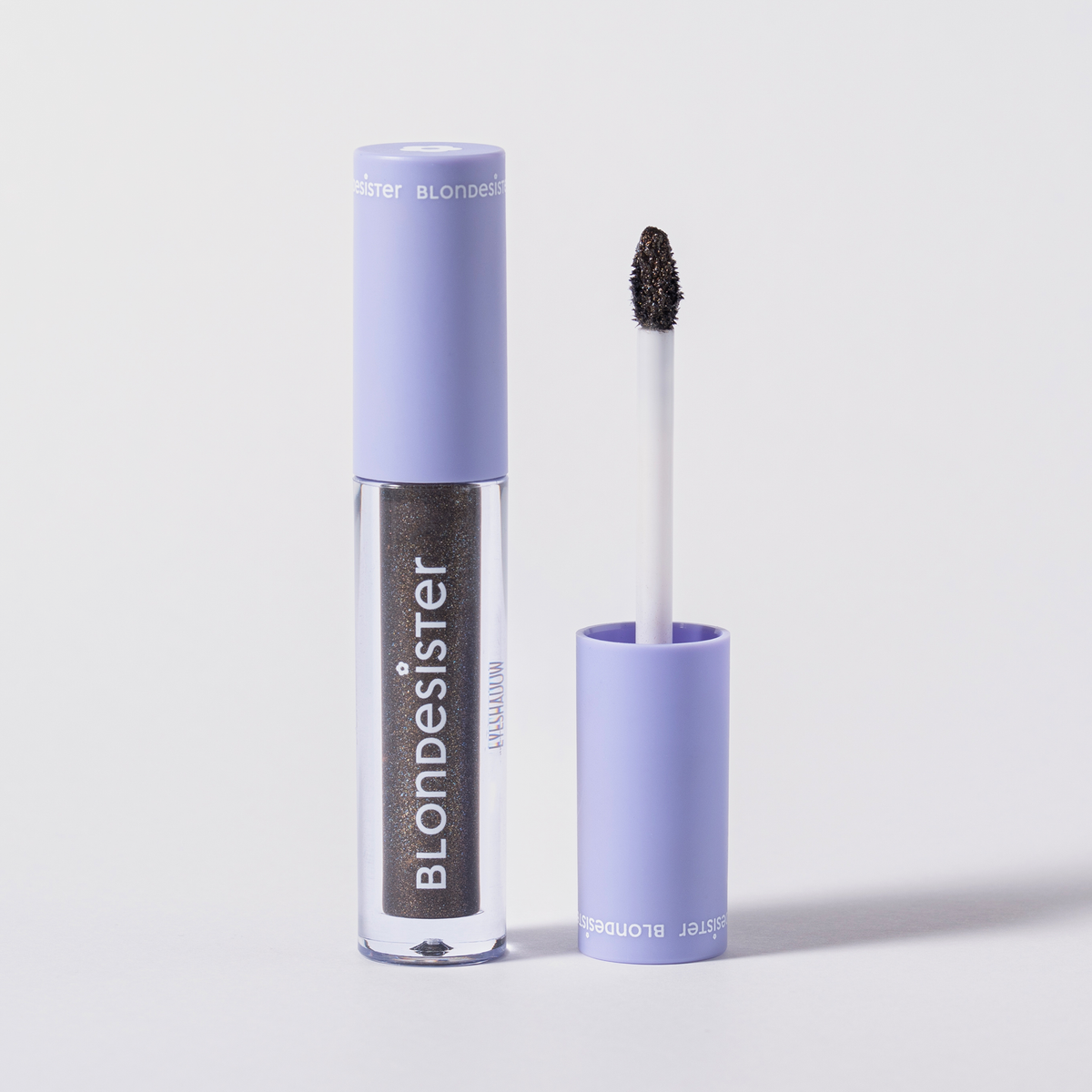 Ein geöffneter GLOWEYE EYESHADOW von BLONDESISTER, dessen Applikator senkrecht neben der Tube steht.