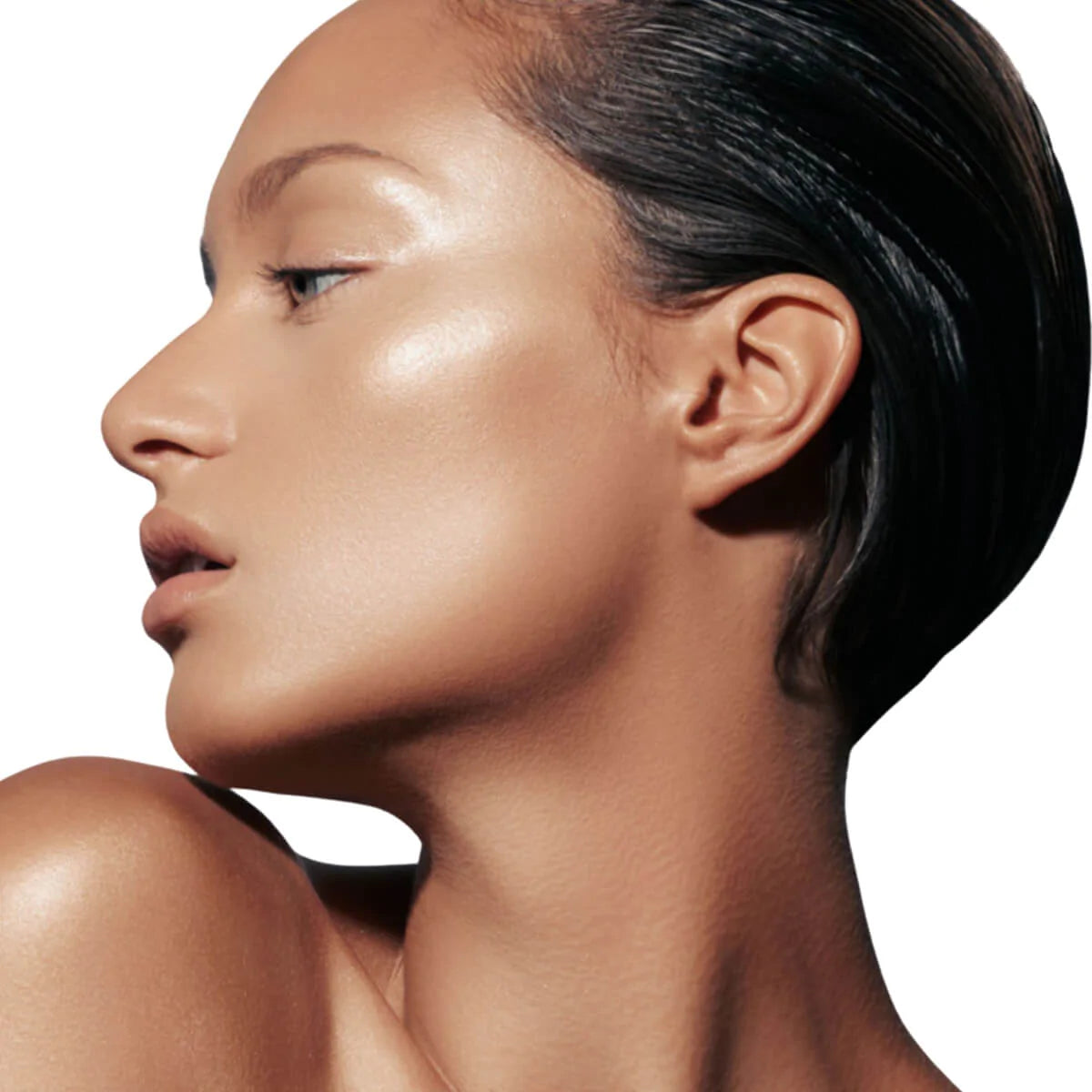 Frau mit glatter, strahlender Haut von Danessa Myricks Beauty Evolution Powder, zurückgekämmtes Haar, im Seitenprofil auf weißem Hintergrund.