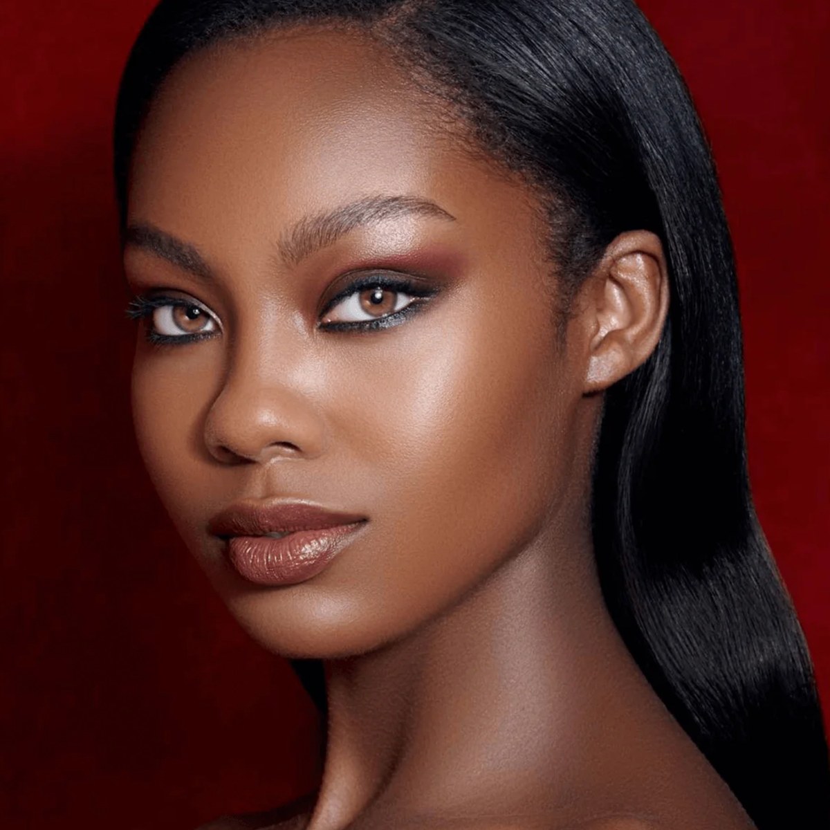 Frau mit glatter dunkler Haut und glattem schwarzem Haar trägt ein auffälliges Make-up mit Danessa Myricks Beauty Evolution Powder.