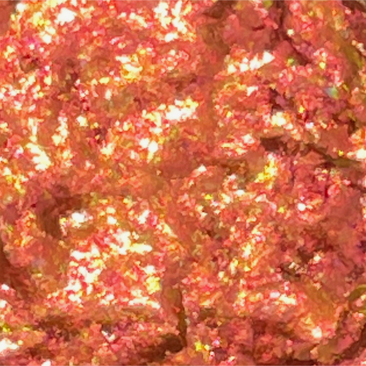 Nahaufnahme von Danessa Myricks Beauty Infinite Chrome Flakes Hot Lava - eine glänzende, strukturierte Oberfläche mit orange-, pink- und gelbfarbenen Tönen, die an zerknitterte Folie erinnert.