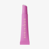 Der Juicy Lip Balm von Dominique Cosmetics in einer rosafarbenen Tube steht aufrecht und trägt einen goldenen vertikalen Text auf der Vorderseite.