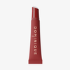Eine rote Tube von Dominique Cosmetics Juicy Lip Balm mit weißem Text, aufrecht stehend auf weißem Hintergrund.