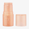 Essence BABY GOT GLOW Highlighter Stick in Pfirsich, hier ohne Kappe und daneben platziert.