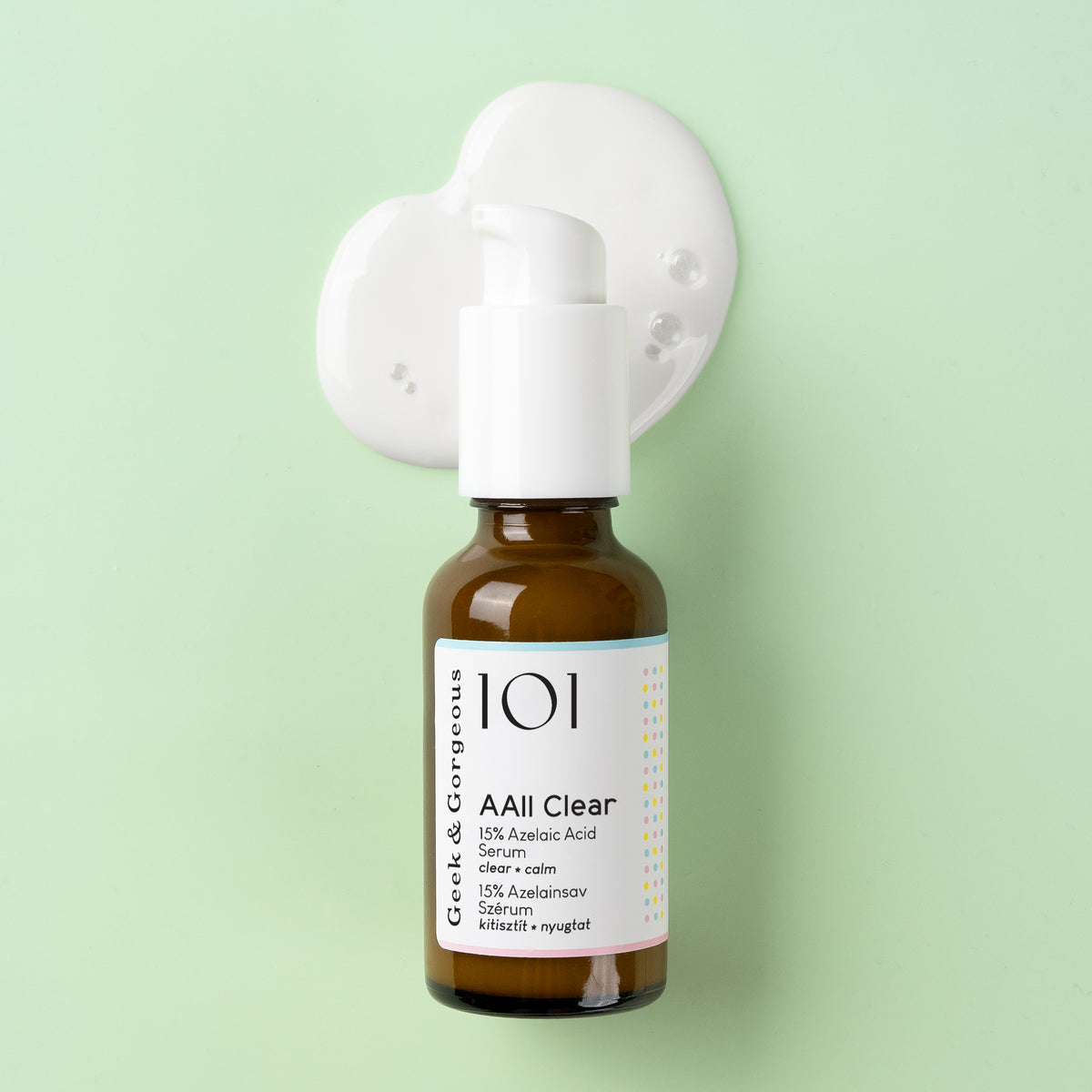 Eine braune Serumflasche mit der Aufschrift „AAll Clear“ von Geek & Gorgeous, gefüllt mit weißer Creme, vor einem pastellgrünen Hintergrund.