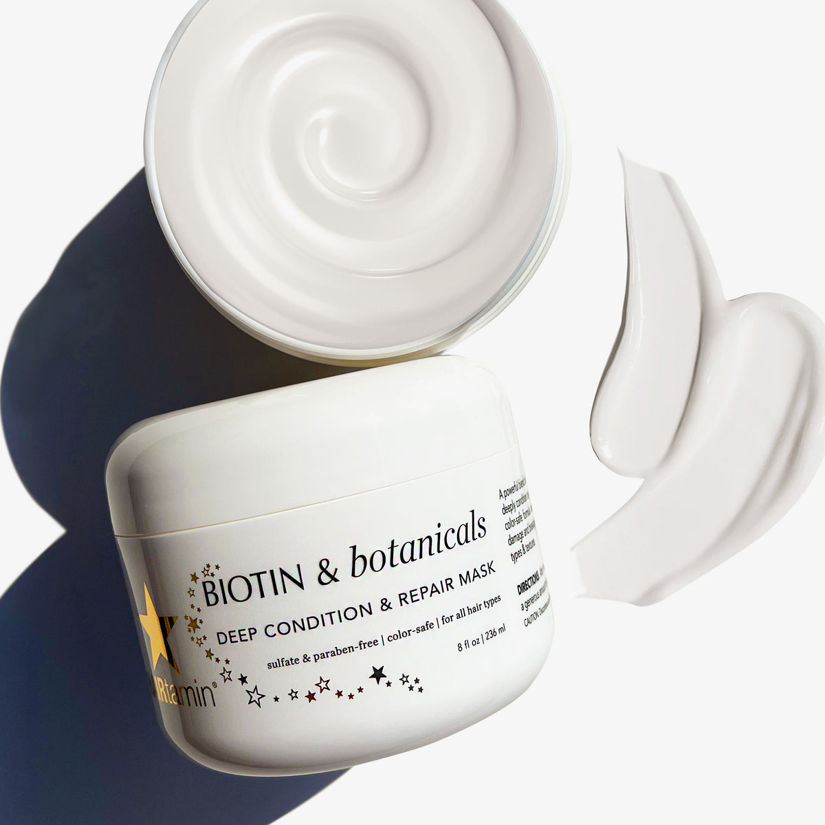Zwei Tiegel HAIRtamin Biotin & Botanicals Deep Condition & Repair Hair Mask neben weißem Swatch, einer geöffnet.