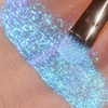 Ein schimmernder, schillernder hellblauer Farbstreifen Opal Multichrome Loose Eyeshadow Dreamer, aufgetragen mit einem Pinsel, auf einem Arm.