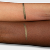 Zwei Unterarme mit je einem grün-glänzenden Crayon Gemma Swatch, um die Farbwiedergabe auf heller und dunkler Haut zu zeigen.