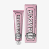 Eine rosa Tube und eine Schachtel Marvis Zahnpasta Sensitive Gums Gentle Mint 75 ml vor weißem Hintergrund.