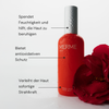 Eine rote MERME Fresh Dew Face Mist Flasche mit Wassertropfen neben einer roten Rose und einem deutschen Text über die Vorteile der Hautpflege.