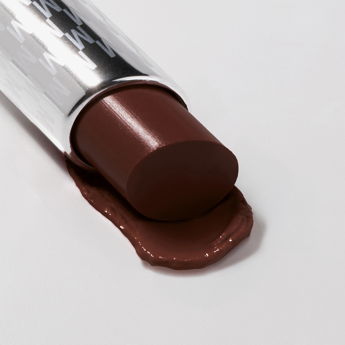 Der braune Lippenstift Hydramorphosis von Mesauda Milano, dessen Spitze auf eine weiße Fläche geschmolzen ist.
