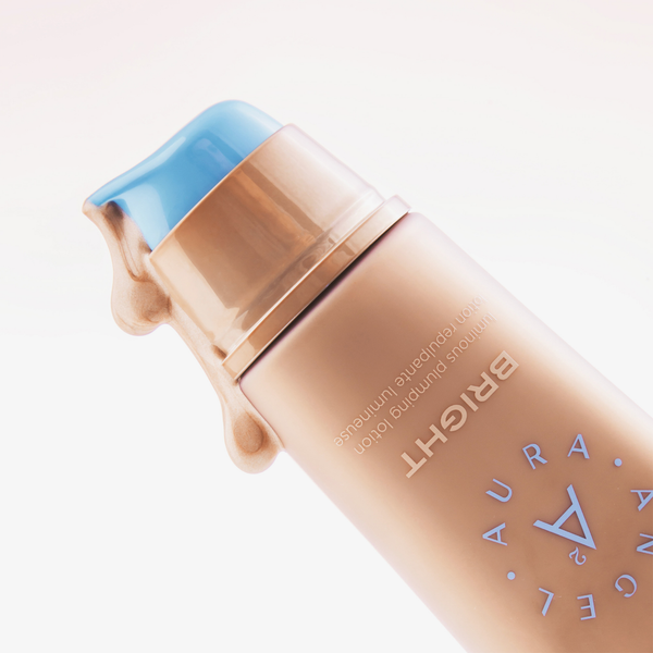 Eine gold-pfirsichfarbene Tube mit einem blauen Pumpspender mit der Aufschrift "Angel Aura Bright" von NABLA Cosmetics, dargestellt vor einem weißen Hintergrund.