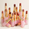 Mehrere geöffnete Nabla Beyond Blurry Lippenstifte in verschiedenen Nude-, Rosé- und Rottönen mit rosafarbenen Hüllen und goldenen Details.