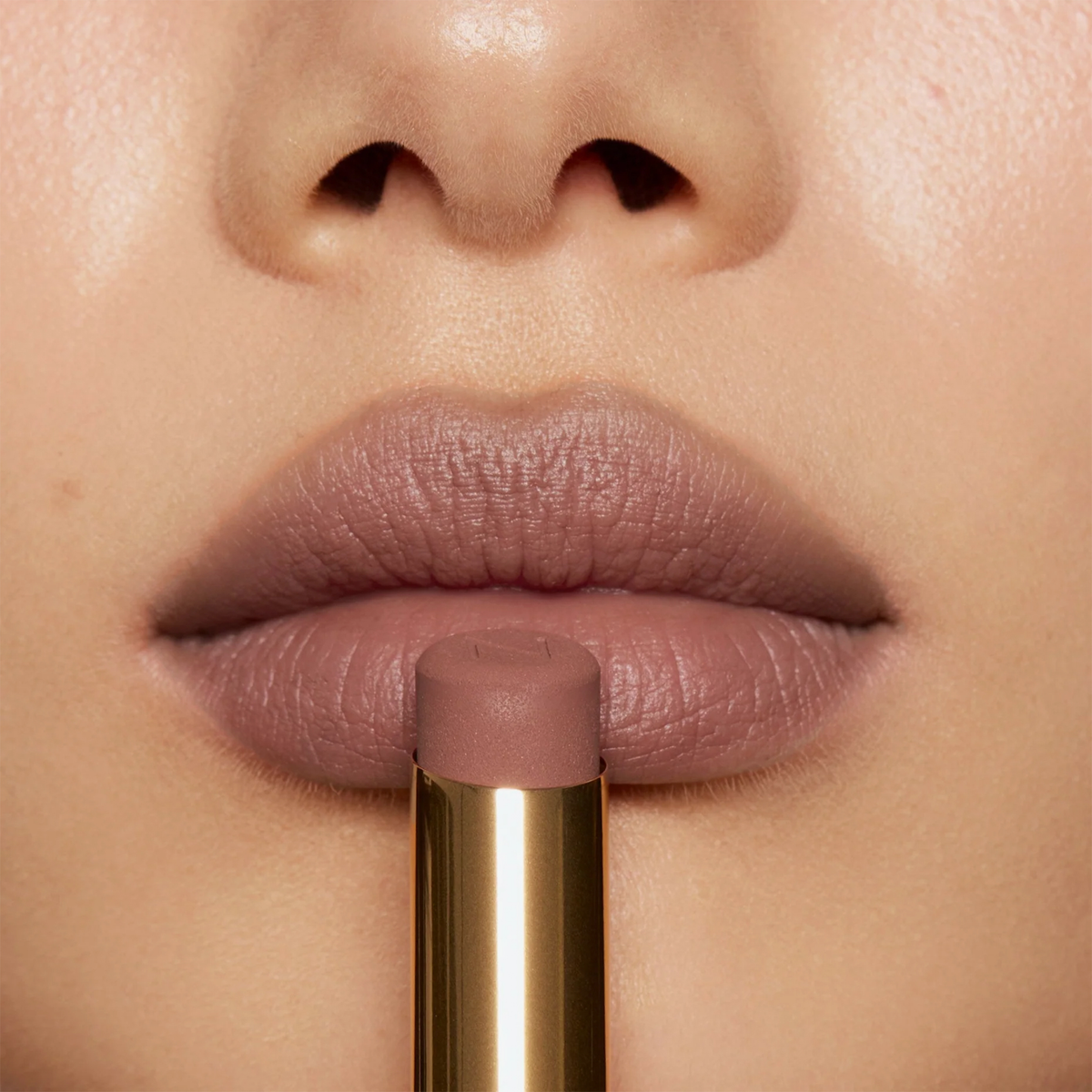 Nahaufnahme von Lippen mit mattem Lippenstift in zartem Rosé-Mauve. Der Lippenstift wird mittig vor den Lippen präsentiert.