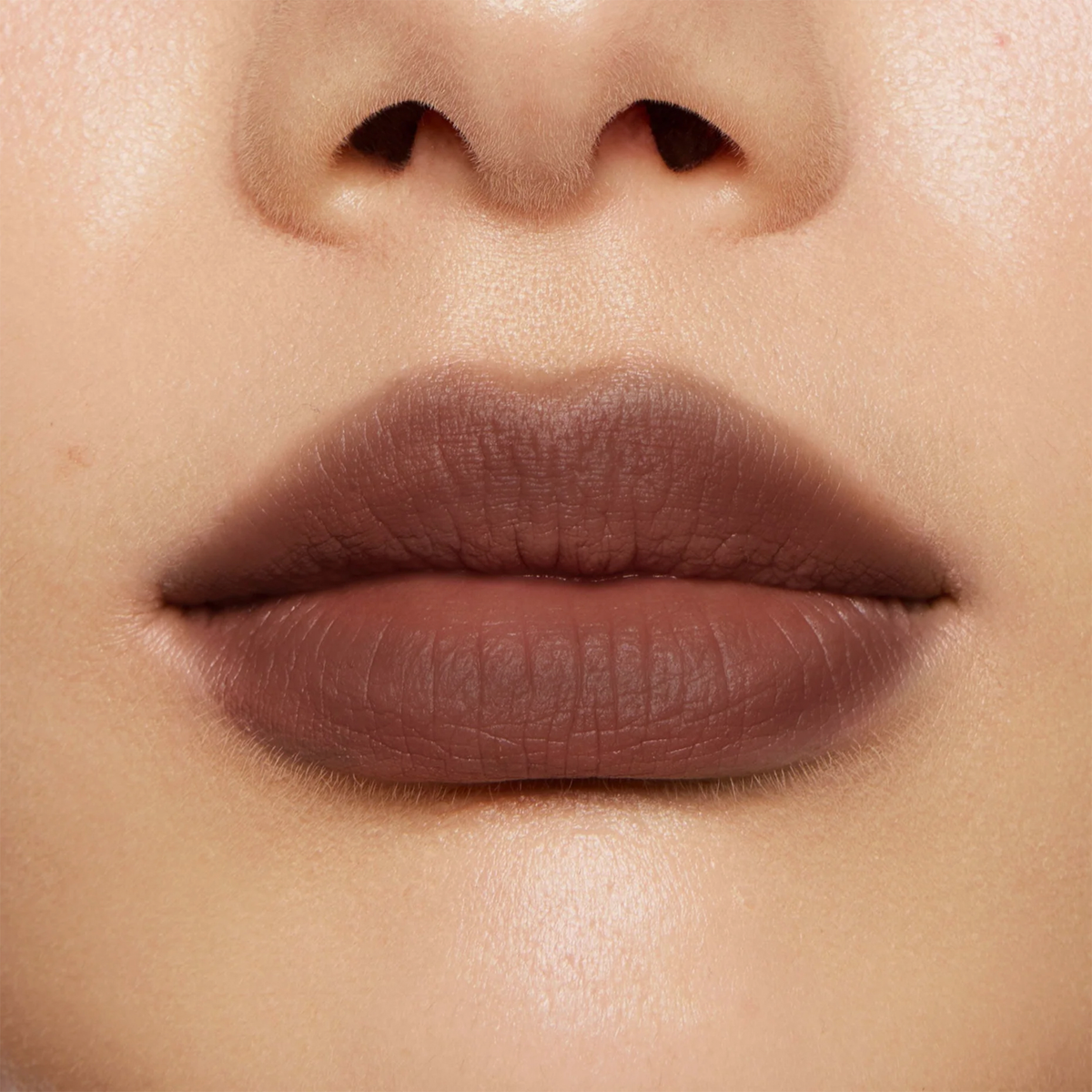 Nahaufnahme von Lippen mit mattem Lippenstift in kühlem Taupe-Braun und weich verblendetem Ombré-Effekt.