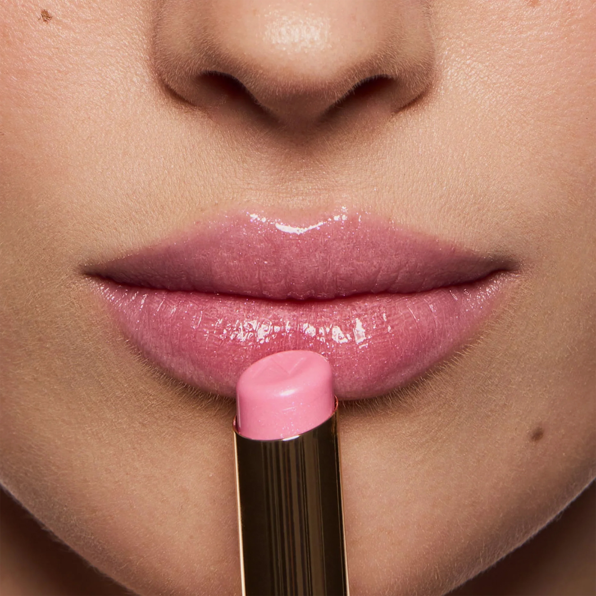 Eine Nahaufnahme von glänzenden rosa Lippen, auf denen der NABLA Cosmetics Beyond Jelly Lipstick Pearlescent aufgetragen wurde.