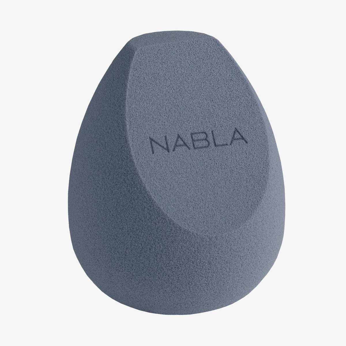 Der NABLA Cosmetics Blended-up Multi-Angled Sponge ist blau mit einer flachen Kante und dem Aufdruck 'NABLA' auf seiner Oberfläche.