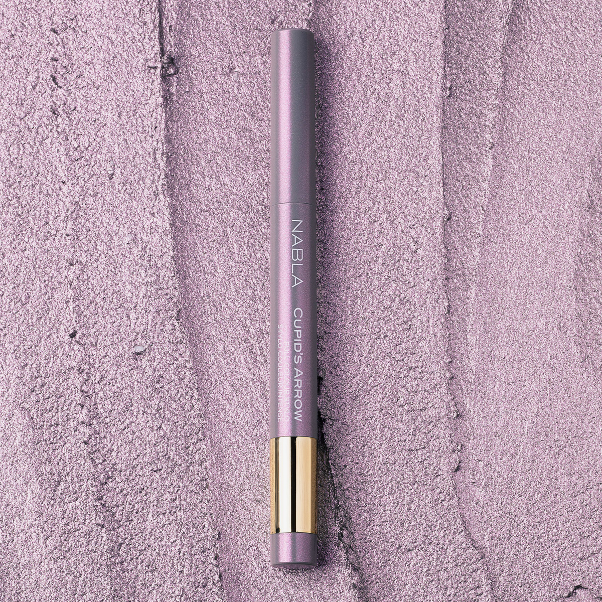 NABLA Cupid’s Arrow Longwear Stylo Arrow Shine in der Nuance Everglow auf strukturierter, schimmernder Oberfläche in Fliedertönen.