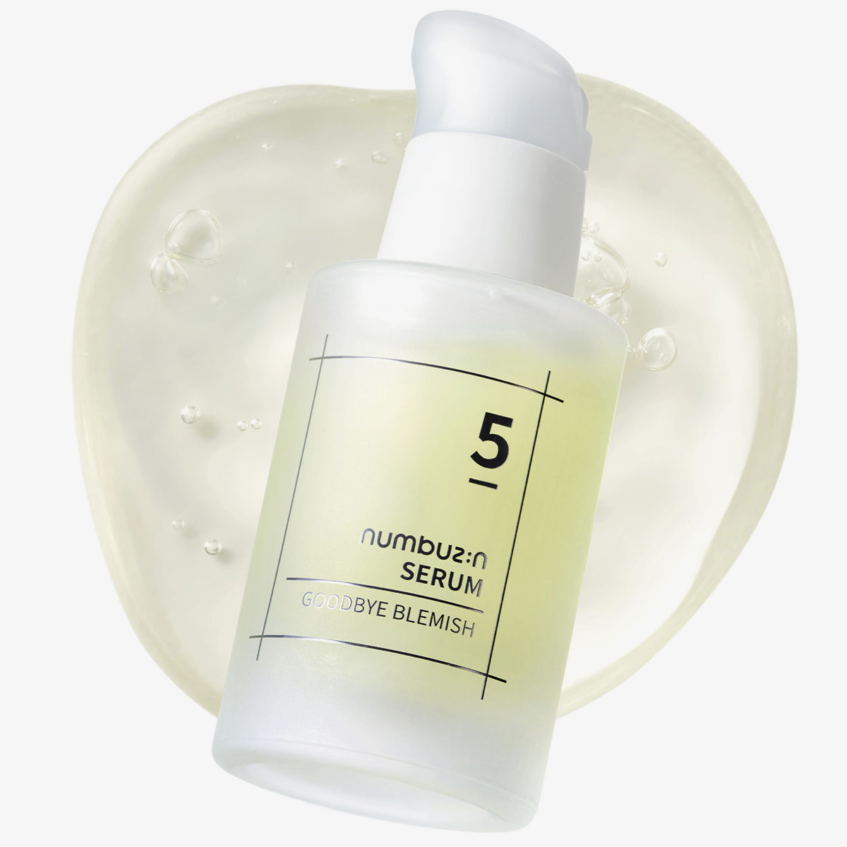 Eine gefrostete Flasche des Numbuzin No.5 Goodbye Blemish Serum ruht auf einer durchsichtigen Serumschicht.