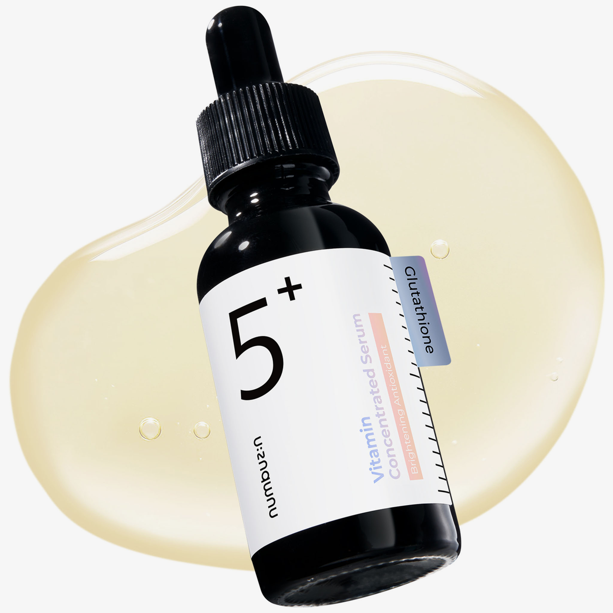 Abgebildet ist eine Tropfflasche No.5+ Vitamin Concentrated Serum, wobei im Hintergrund ein hellgelber Ausstrich des Serums zu sehen ist.