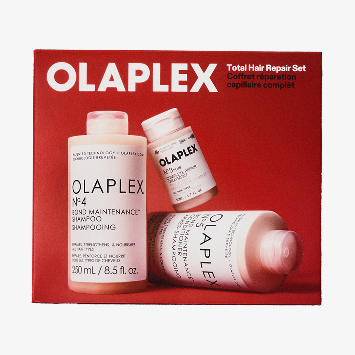 Eine rote OLAPLEX Total Hair Repair Holiday Kit 2026-Geschenkbox mit drei Haarpflegeflaschen.
