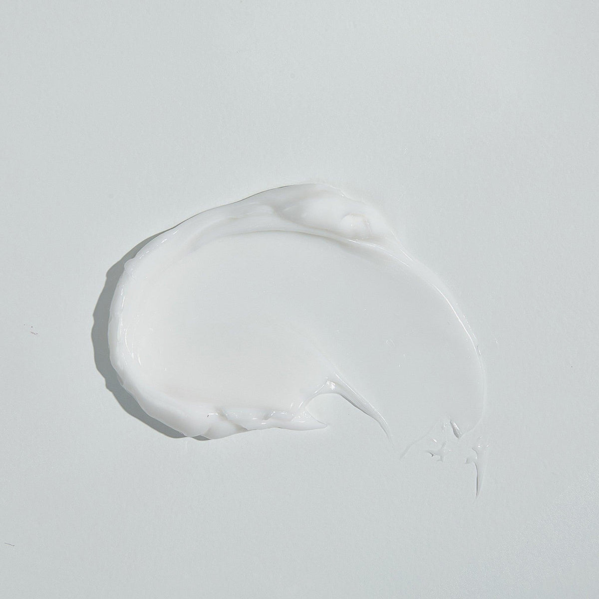 Ein weißer Abstrich von ROUND LAB 1025 Dokdo Cream auf einer glatten, hellen Oberfläche.