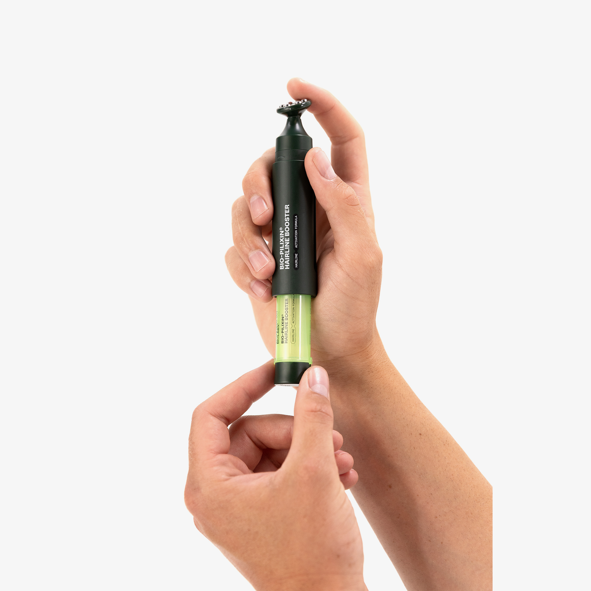 Jemand setzt eine grüne Bio-Pilixin® Hairline Booster-Kartusche von Scandinavian Biolabs in den dunkelgrünen Applikator vor einem weißen Hintergrund ein.