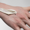 Nahaufnahme einer Hand mit einem Streifen Scandinavian Biolabs Firm Hybrid Clay auf dem Handrücken.