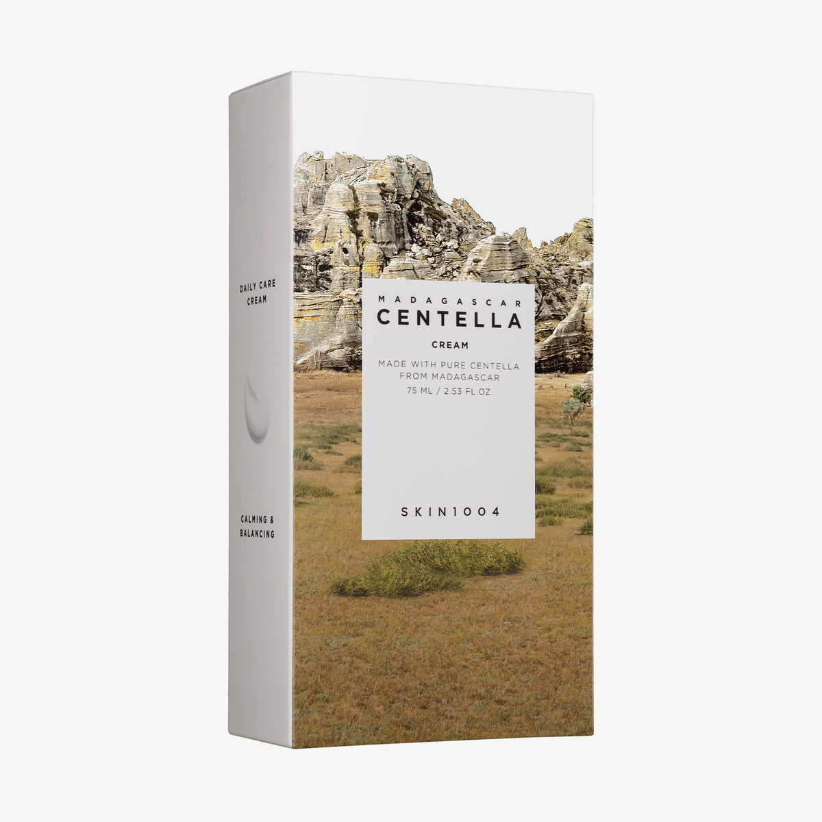 Eine Schachtel SKIN1004 Madagascar Centella Cream mit einer Verpackung, die ein Bild von felsigem Gelände und Gras zeigt.