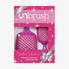 Das UNbrush Glitter Duo Set Rose Quartz Pink besteht aus zwei glitzernden Haarbürsten in einer rosafarbenen Geschenkbox mit silberner aufgedruckter 
Schleife.