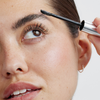 Eine Person, die das XLASH Brow Booster-Augenbrauengel mit einem Applikator aufträgt.
