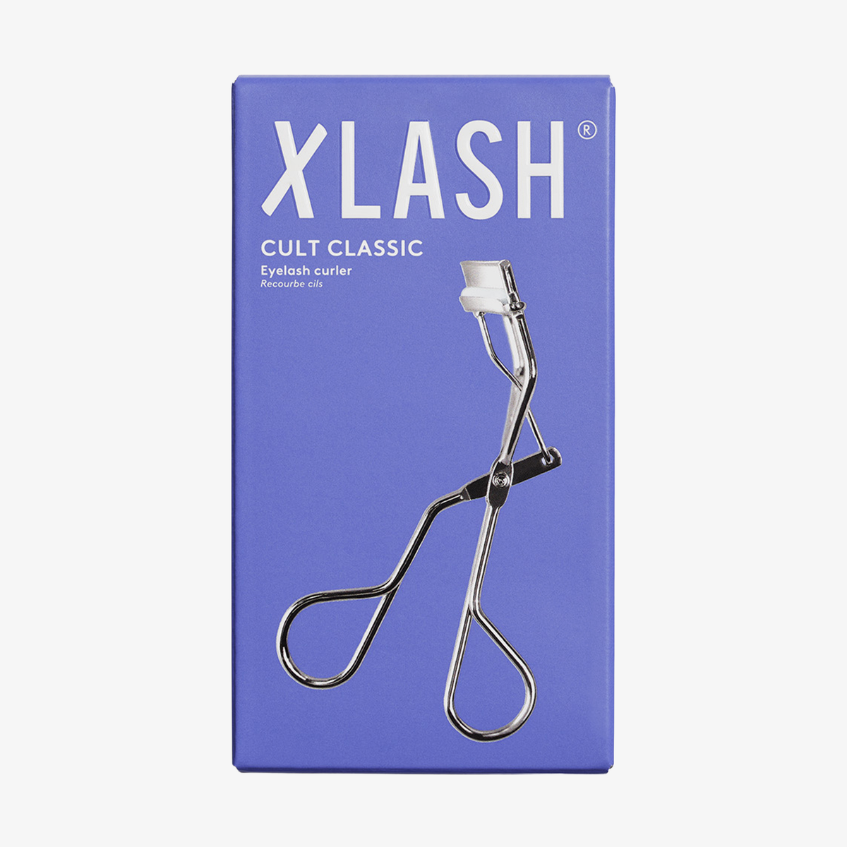 Silberne Wimpernzange auf der violetten Verpackung der XLASH Cult Classic Wimpernzange.